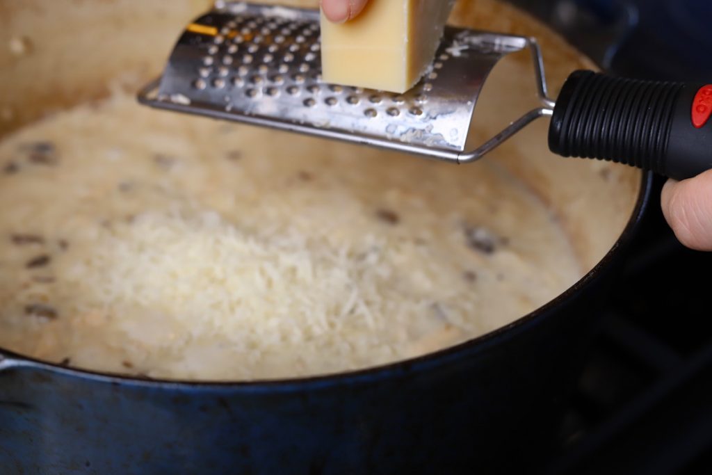 grating parmesan cheese into risotto